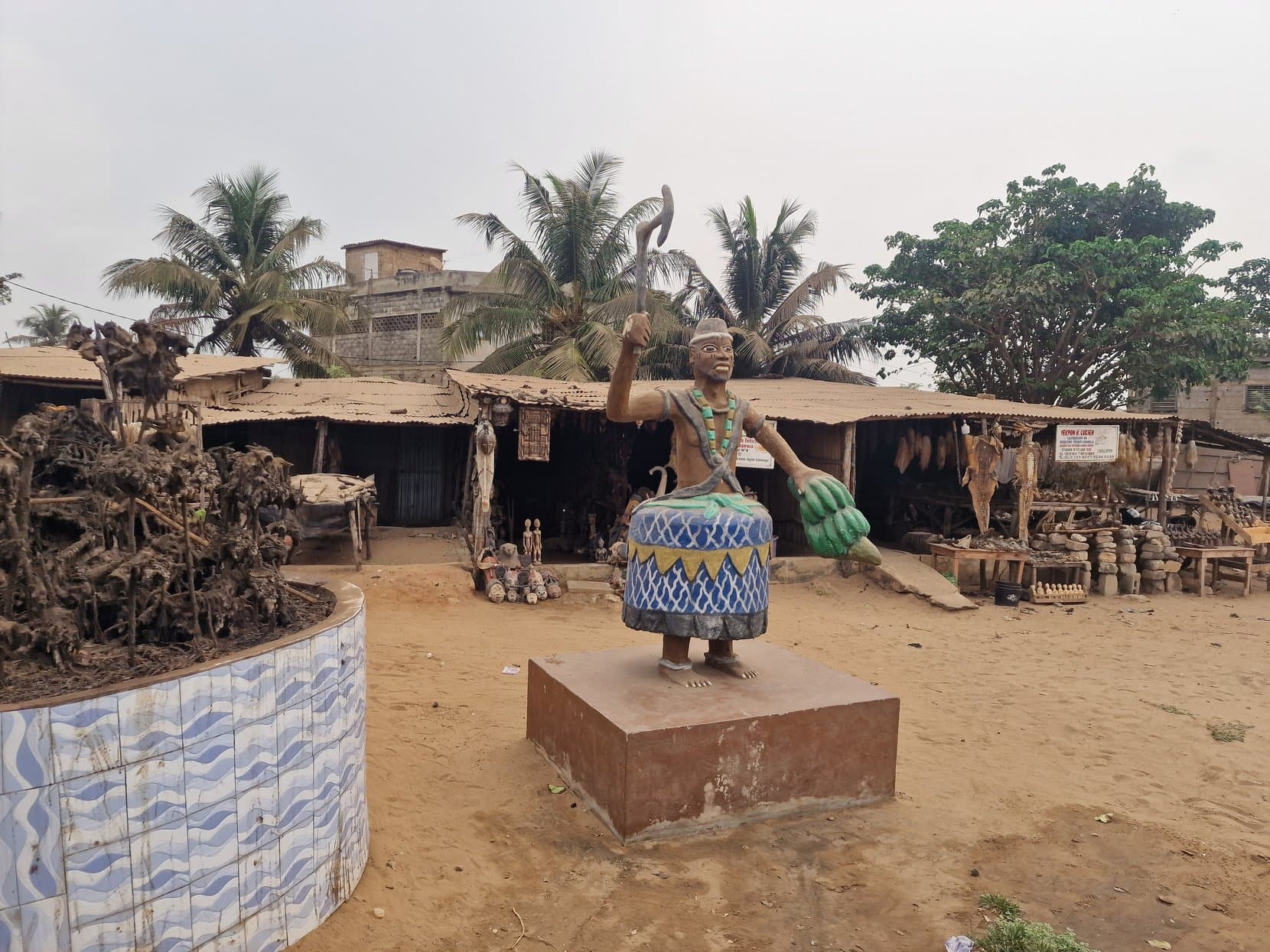 The open yard of Akodessawa fetish market with a carved figure on a plinth, Lomé, Togo