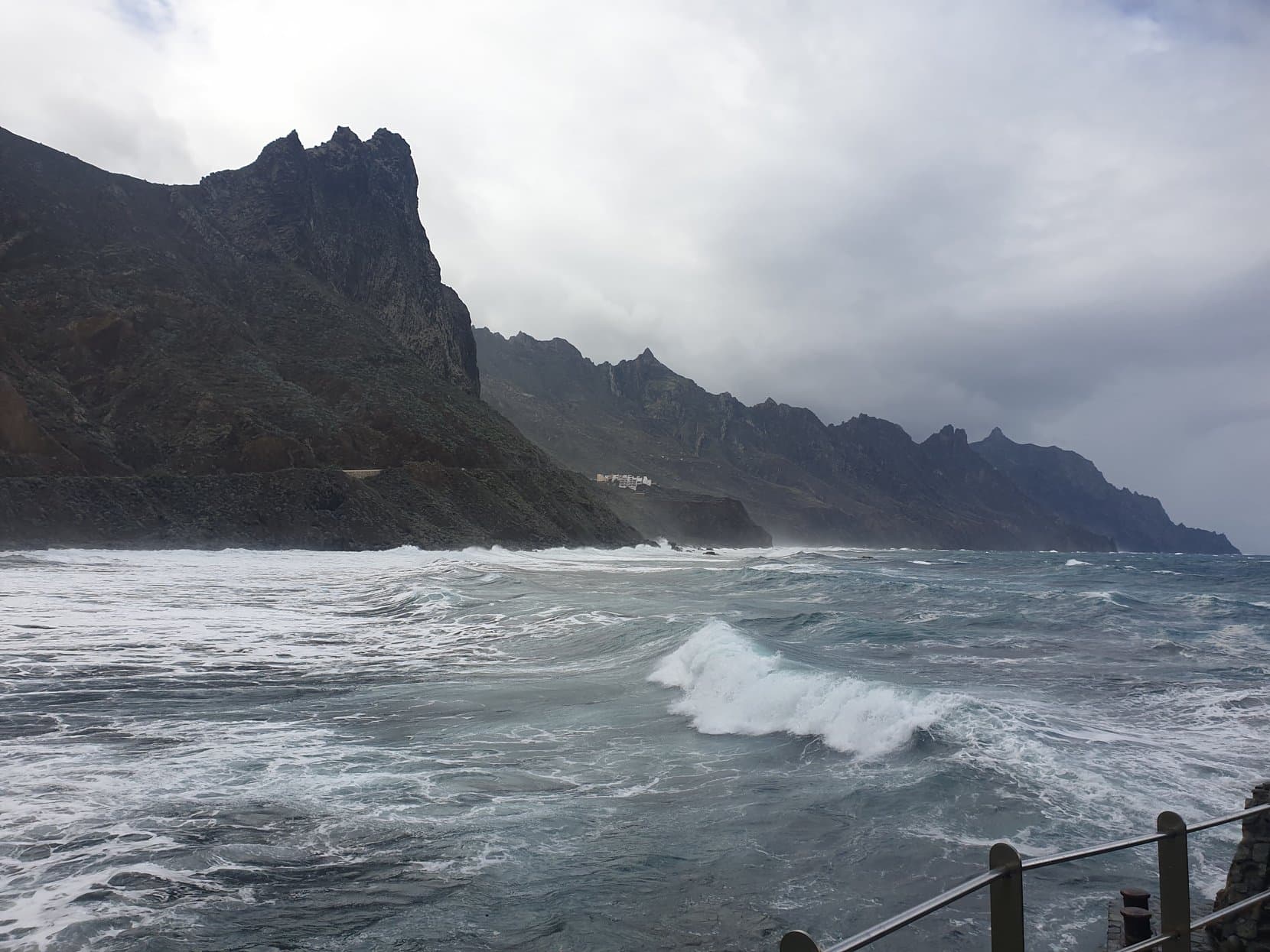 A wave breaking hard against the rocks under dark Anaga cliffs, Tenerife