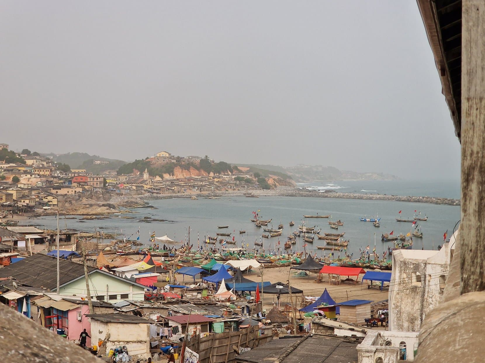 Cape Coast town and its harbour full of painted fishing boats, seen from the castle above, Ghana