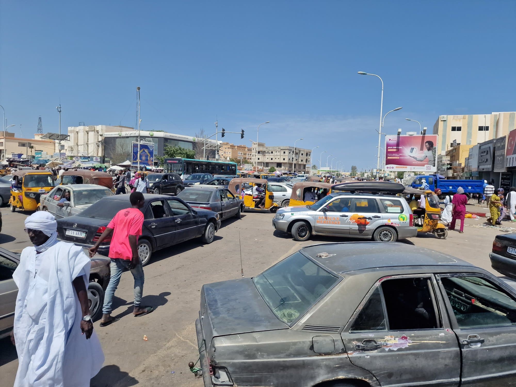 Battered old Mercedes sedans in slow Nouakchott traffic