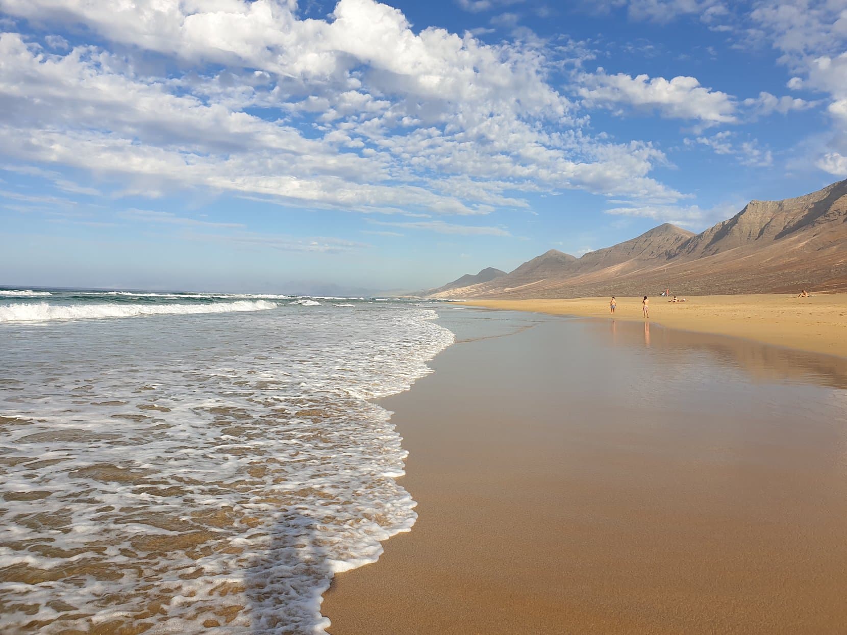 Surf lines rolling onto Cofete's empty sand under the Jandía wall, Fuerteventura