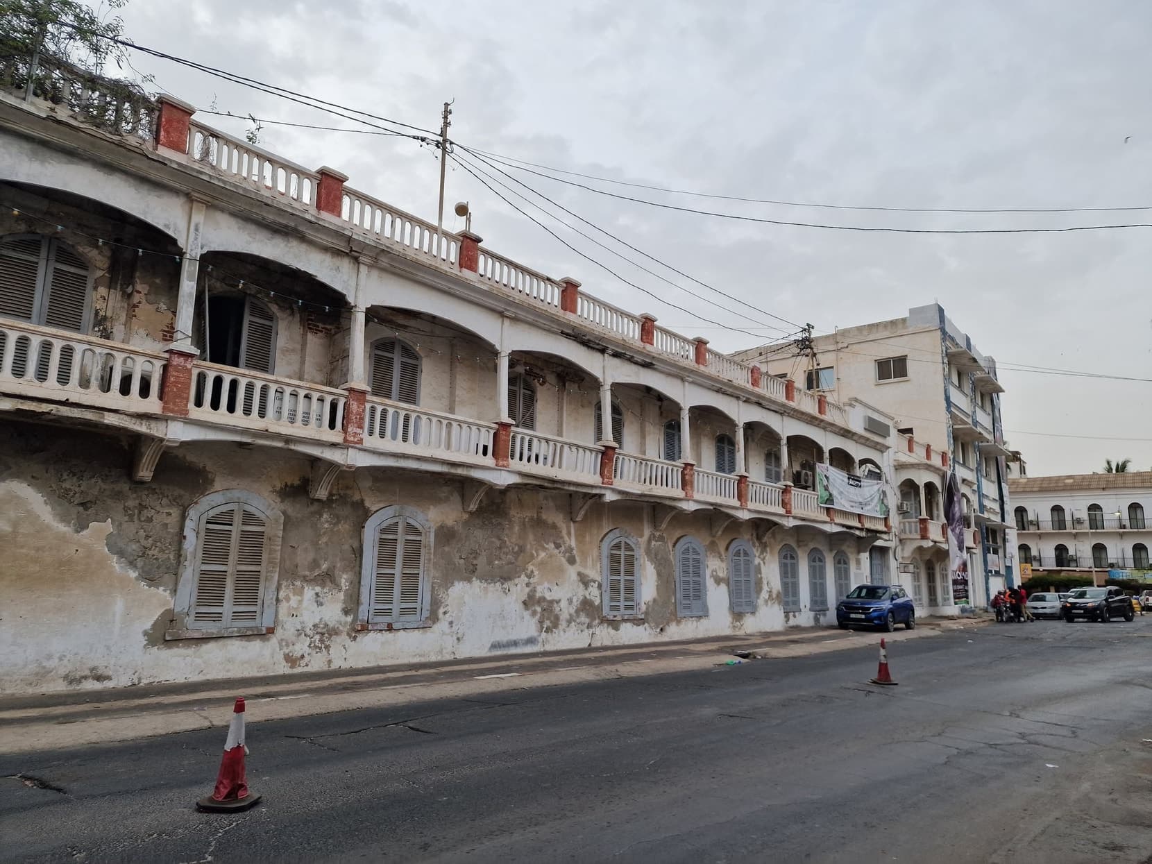 A row of balconied colonial buildings with peeling paint on the island of Saint-Louis