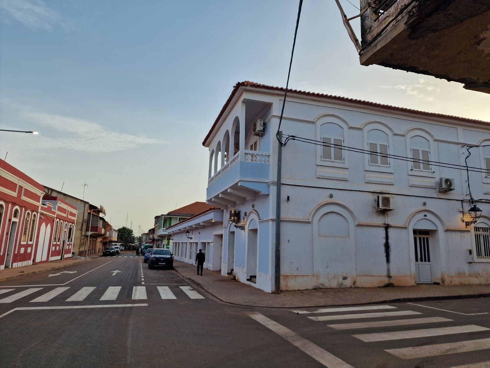 A crossing in Bissau's old town between two-storey colonial buildings with balconies and shutters