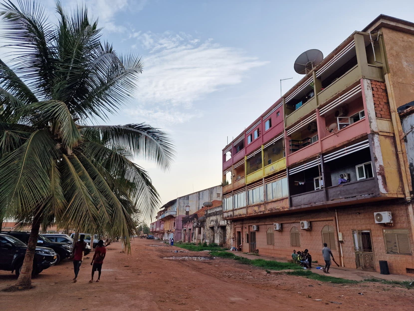 Palms leaning over a red dirt street of decaying colonial buildings in Bissau Velho, Guinea-Bissau