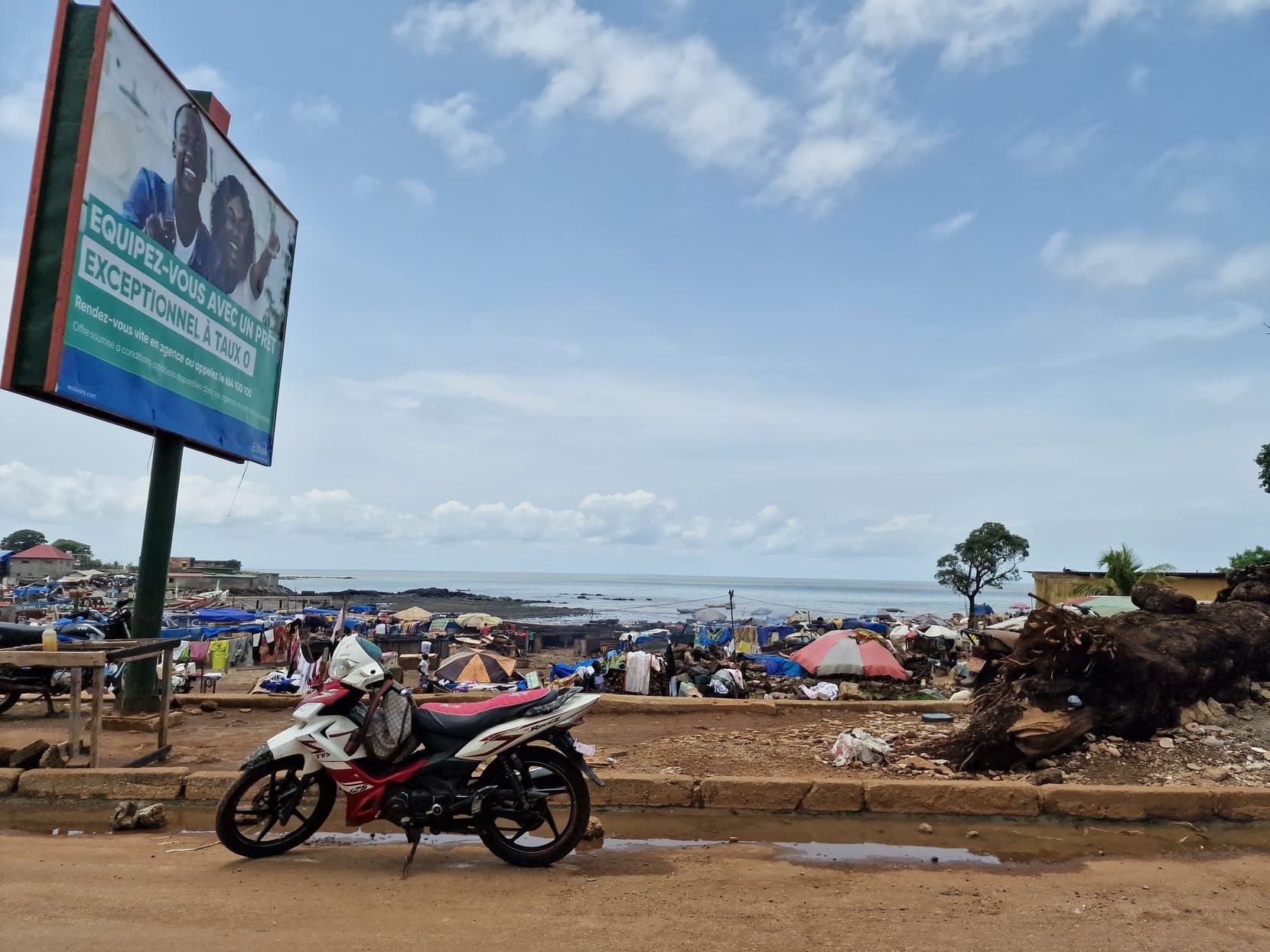 Stalls, low houses and the Atlantic along the shore in Conakry, Guinea