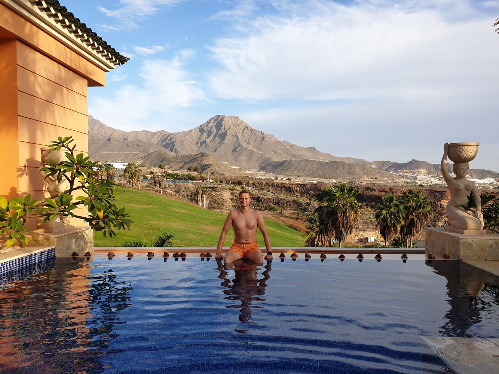 The founder in a Costa Adeje infinity pool, bare mountains behind, Tenerife