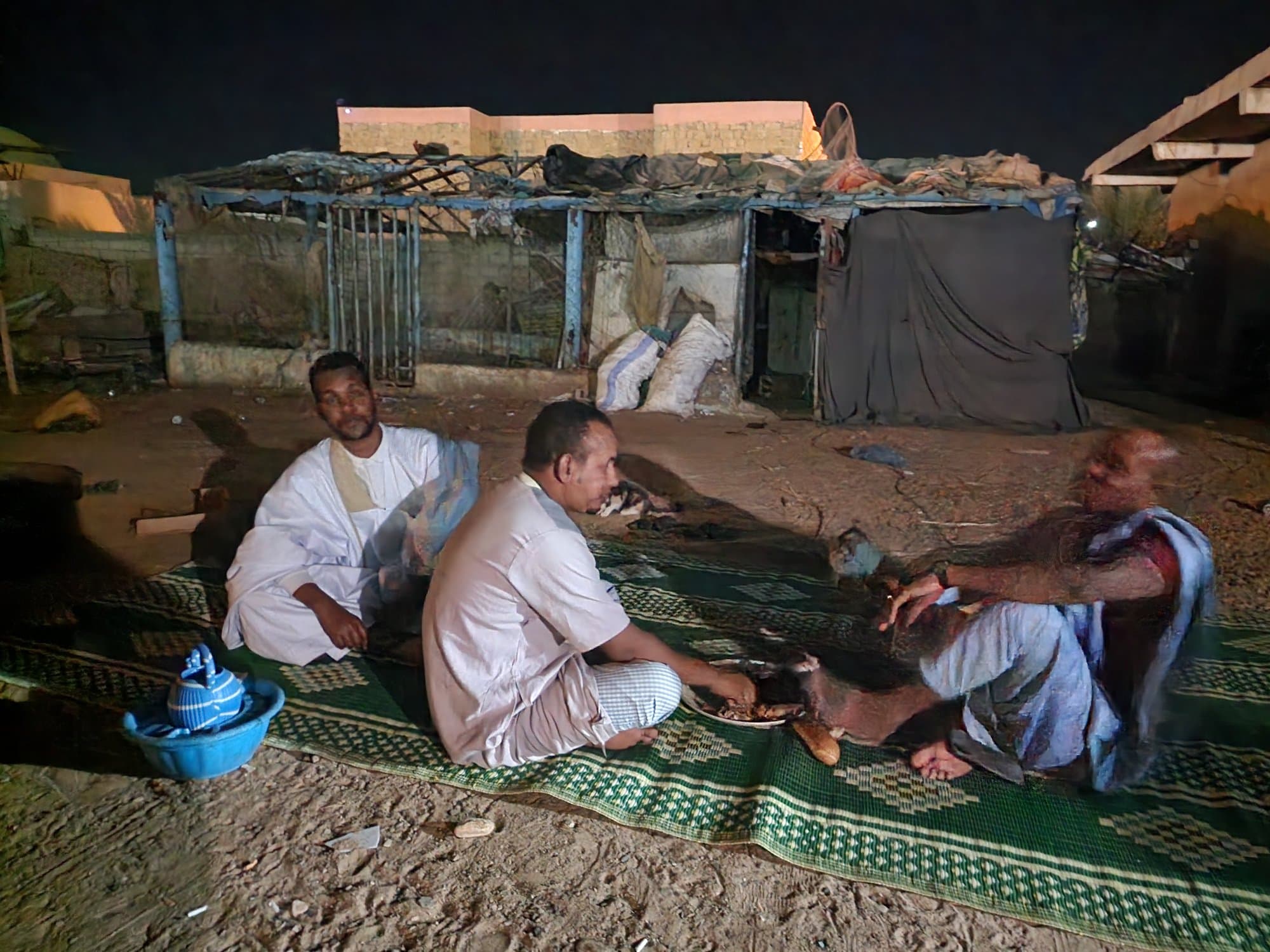 Dinner on a mat at night with local hosts in the desert