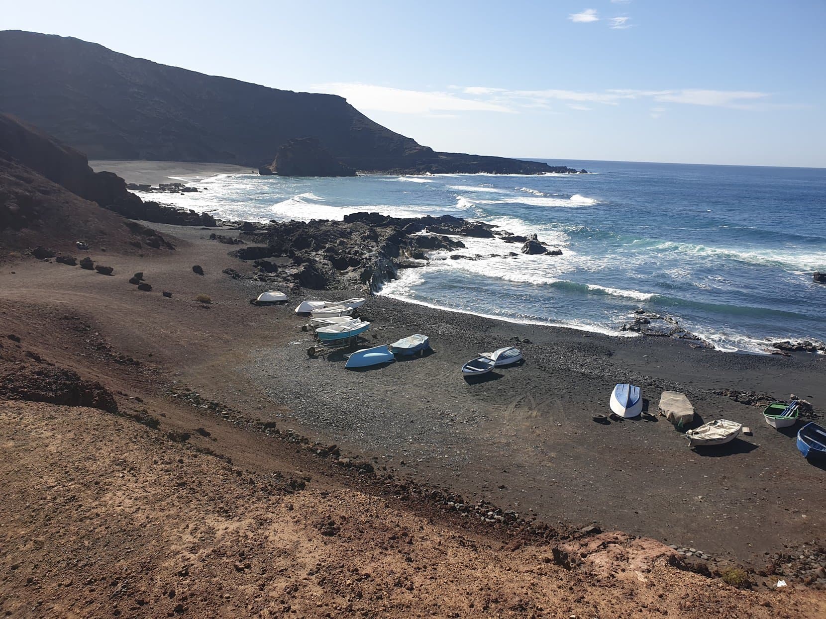 Fishing boats on the black beach below the cliffs at El Golfo, Lanzarote