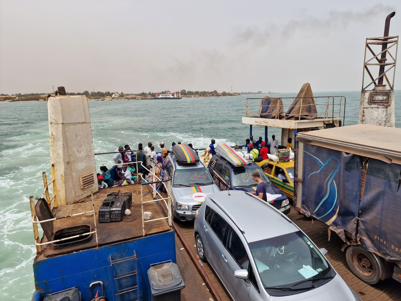 The loaded ferry deck mid-river, cars and trucks packed together