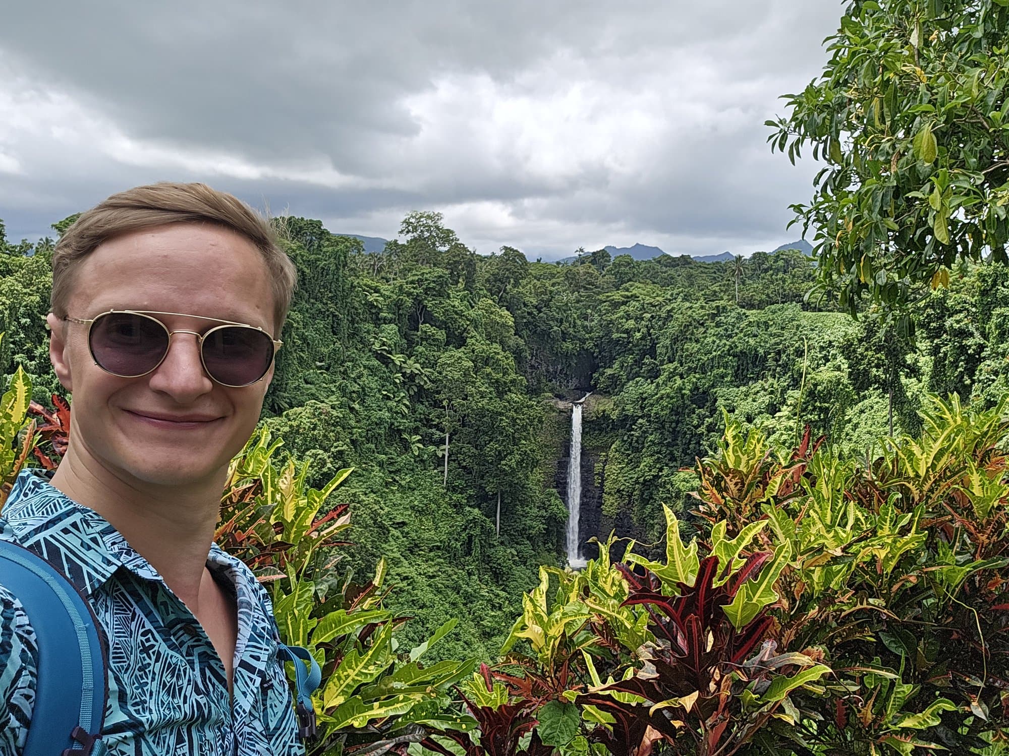 The founder at the Sopo'aga Falls lookout, the fall dropping into its jungle gorge behind