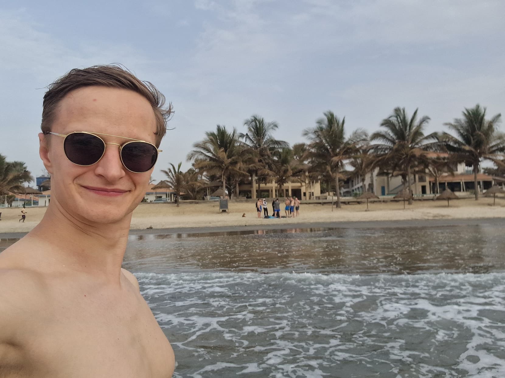 The founder in the surf off the Atlantic strip, palms and the beach hotels behind