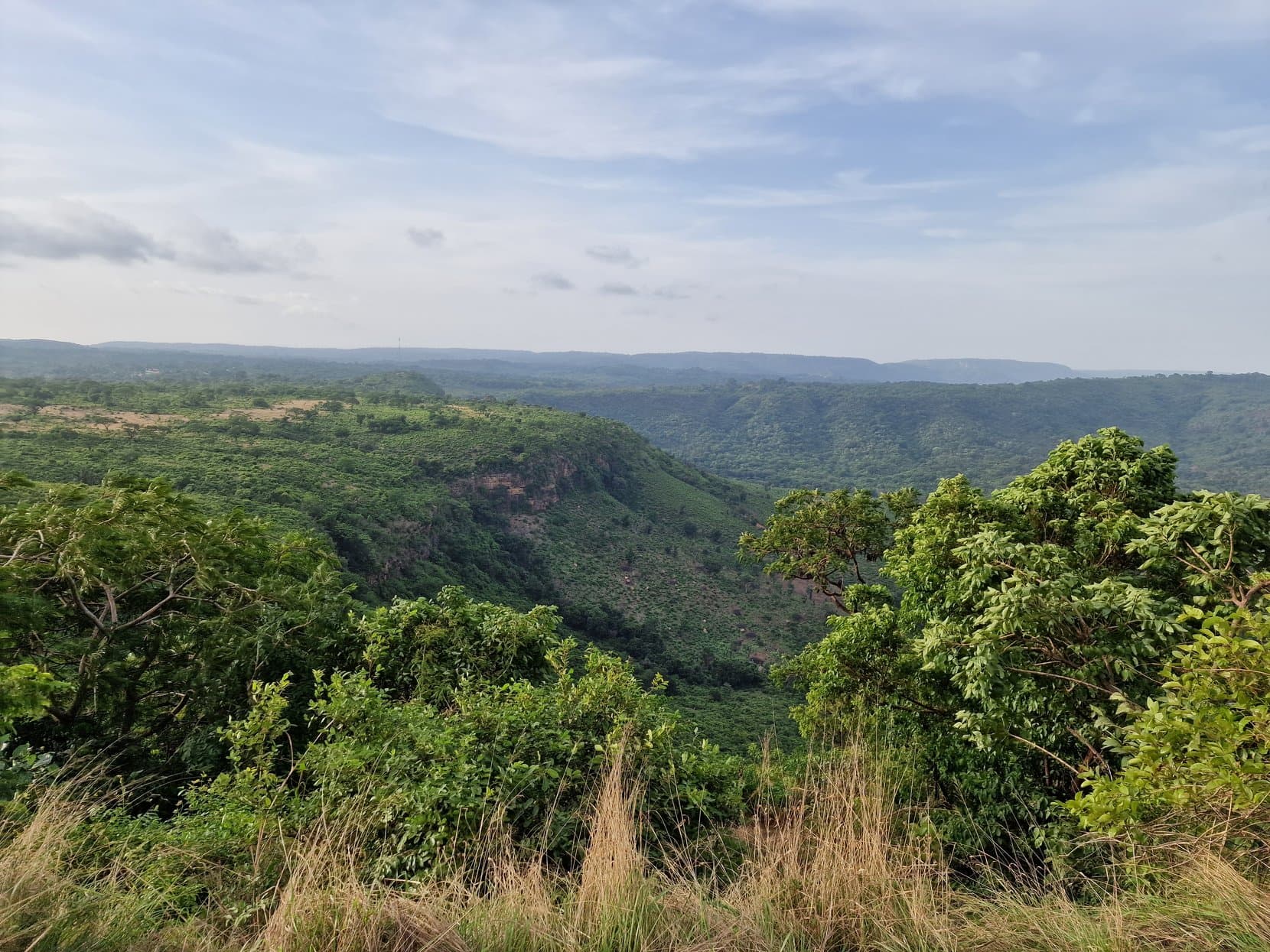 Wide green valleys and plateau edges of the Fouta Djallon seen from the roadside, Guinea