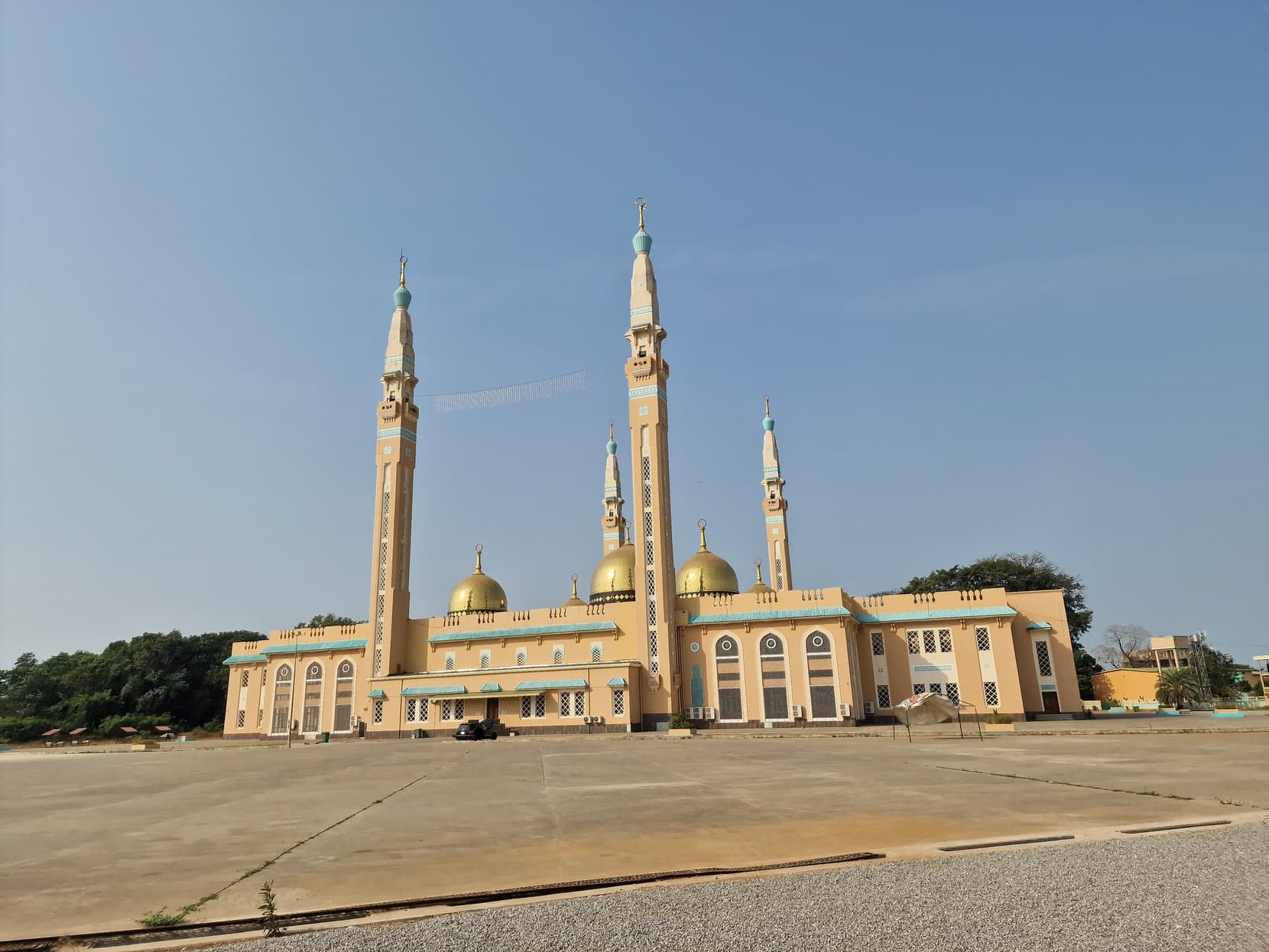 The four minarets and golden domes of the Grande Mosquee Faycal above its empty forecourt, Conakry