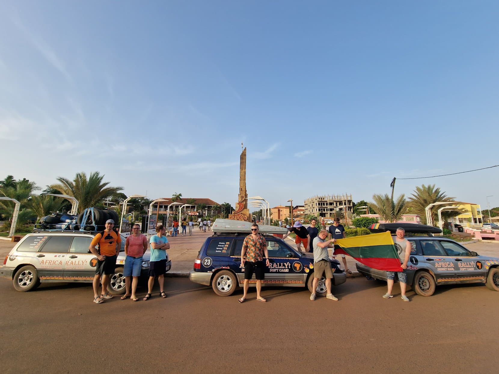 The rally group holding a Lithuanian flag beside the independence monument in Bissau