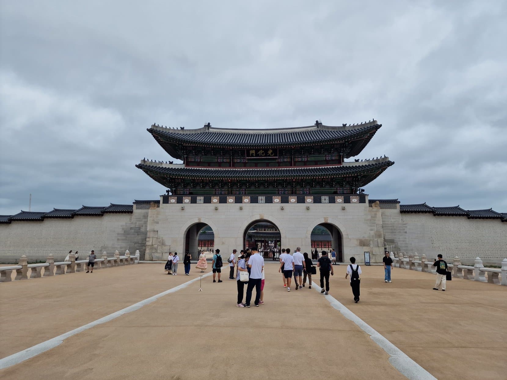 Gwanghwamun, the main gate of Gyeongbokgung palace, wide across its forecourt with visitors below, Seoul, South Korea