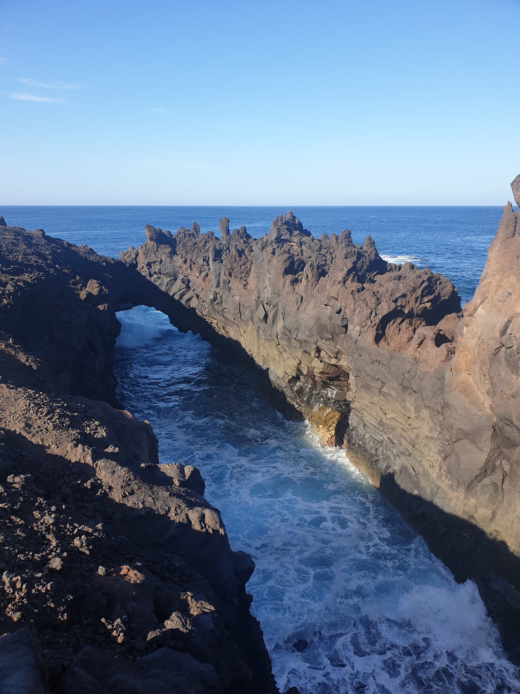 Surf churning through a black lava arch at Los Hervideros, Lanzarote