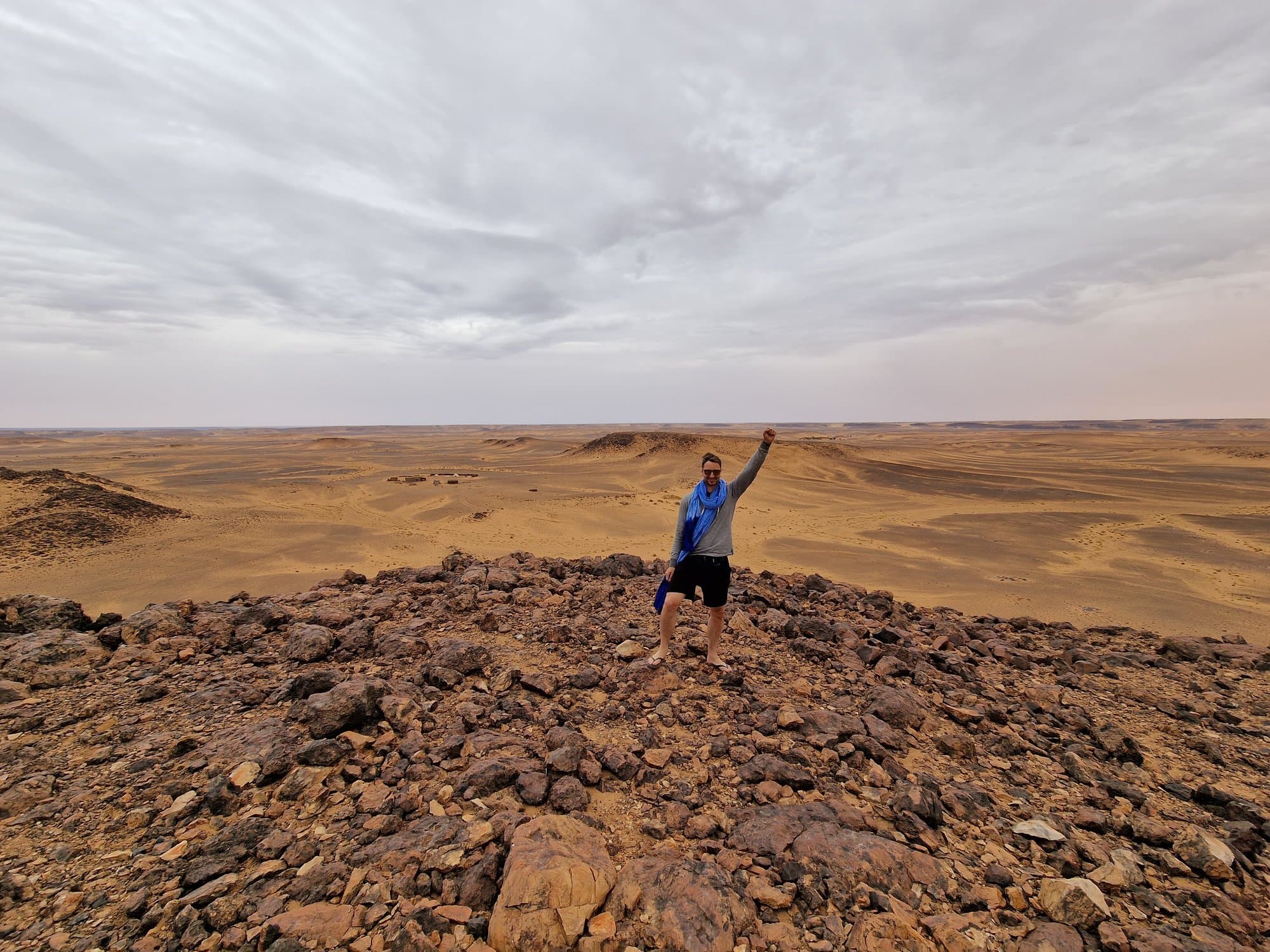 A lone figure on a black-rock ridge inside the Richat Structure