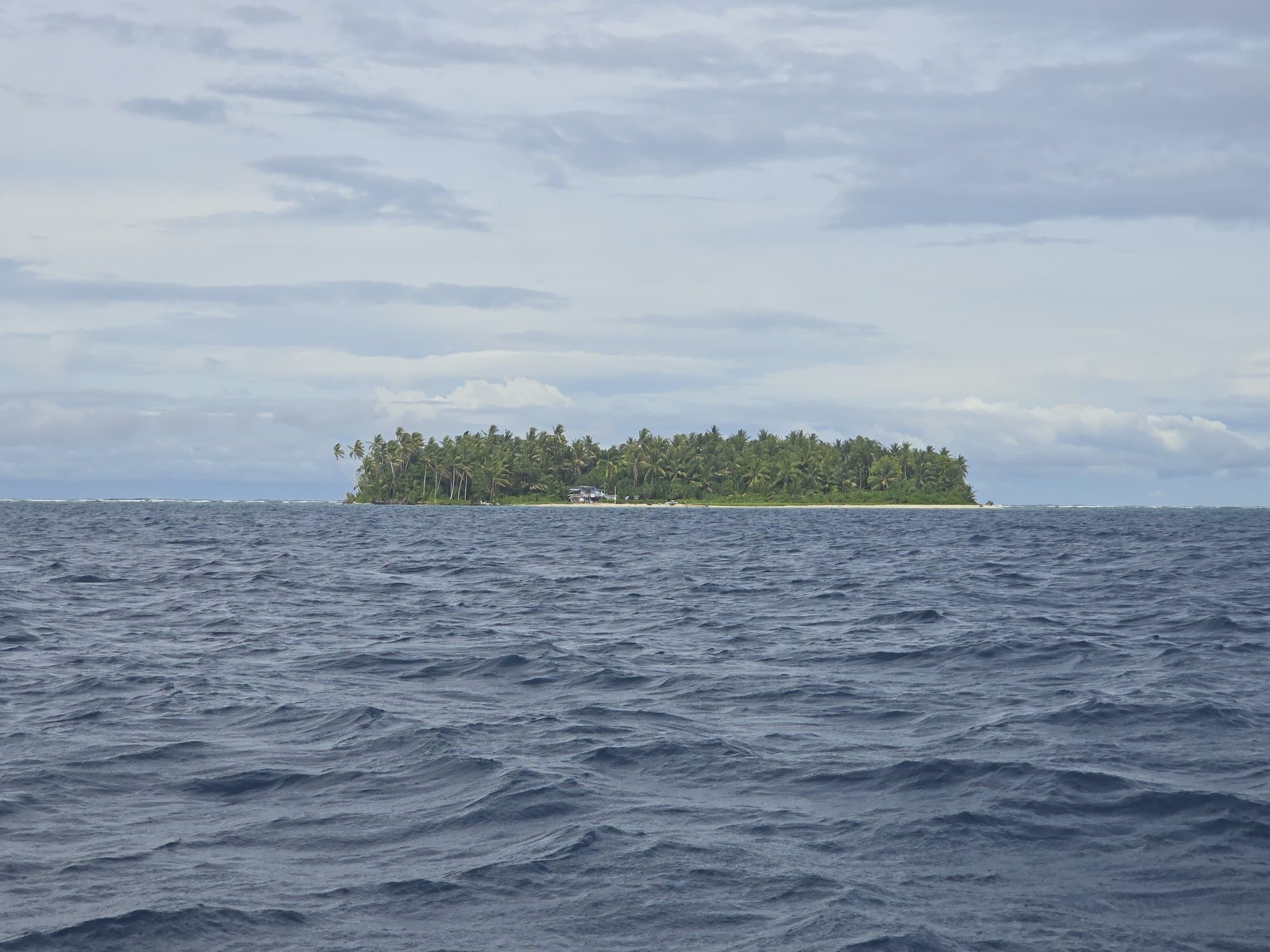 A lone islet in deep-blue open ocean