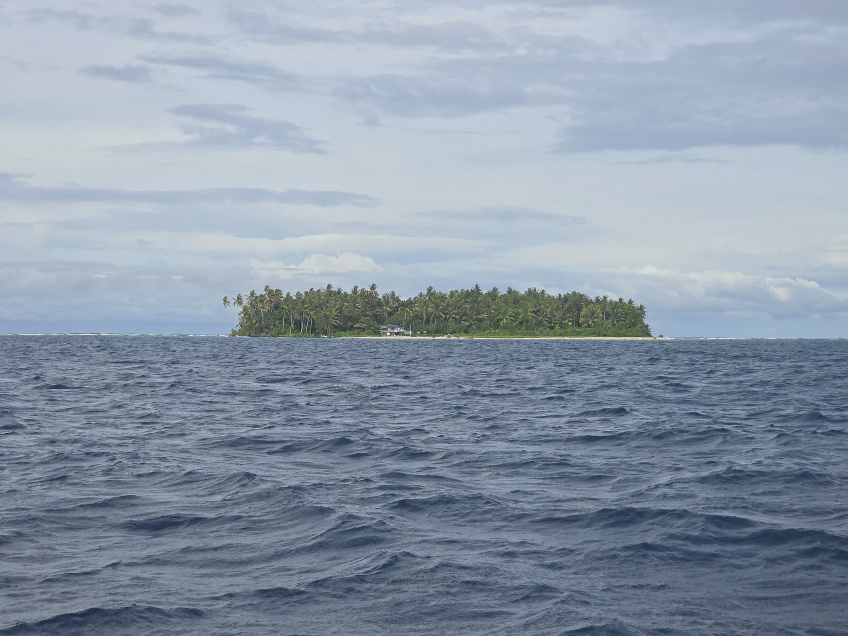 A lone islet in deep-blue open ocean