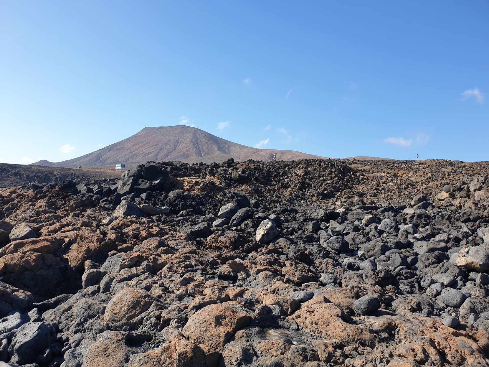 A black lava field running to a bare volcano cone, Fuerteventura