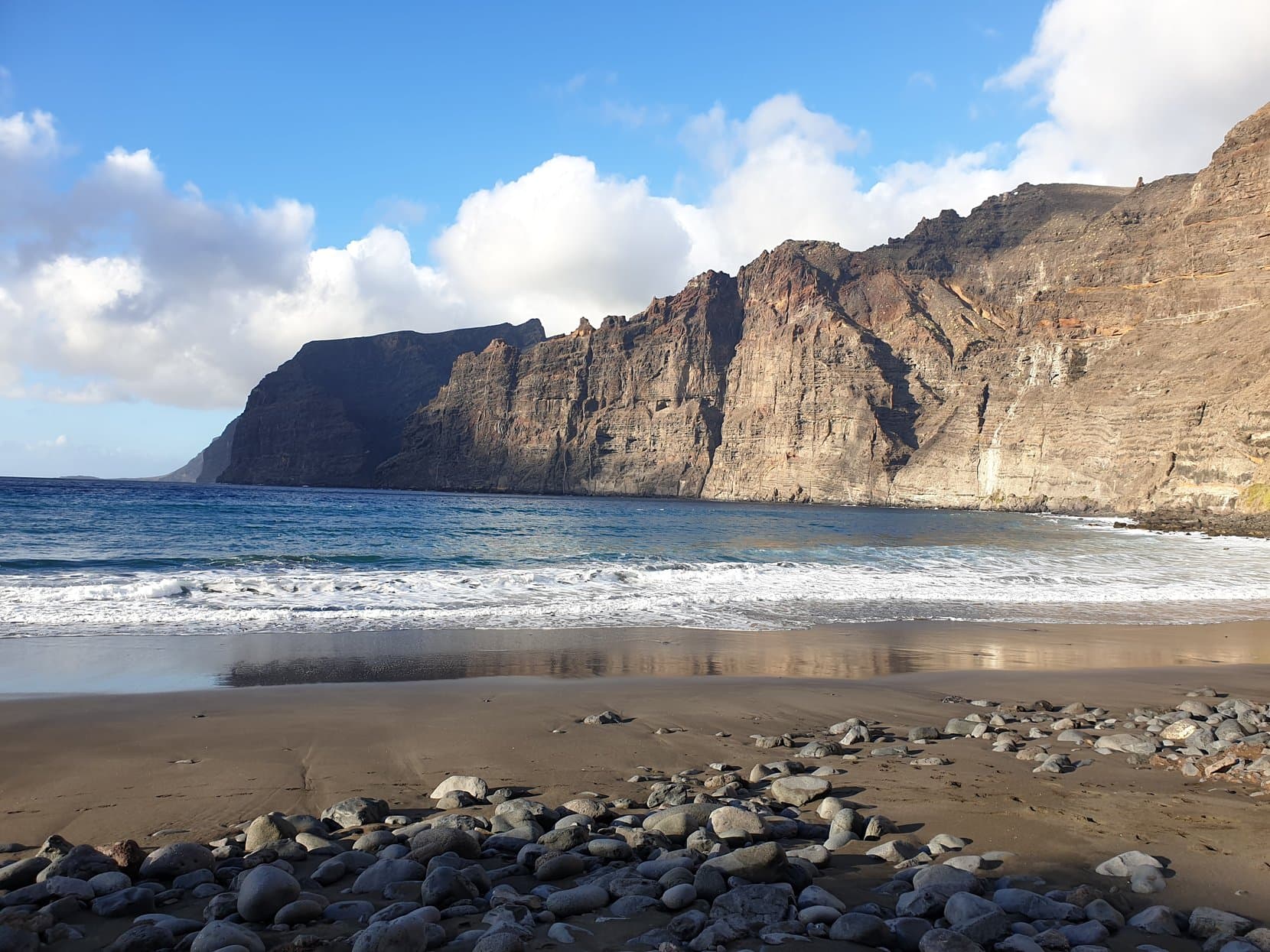 The sheer cliff wall of Los Gigantes above the black sand of Playa de los Guíos, Tenerife
