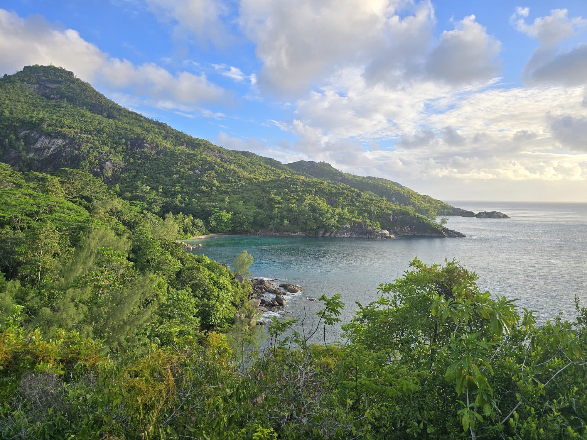 Green ridges dropping to a sheltered cove on the coast of Mahé, Seychelles