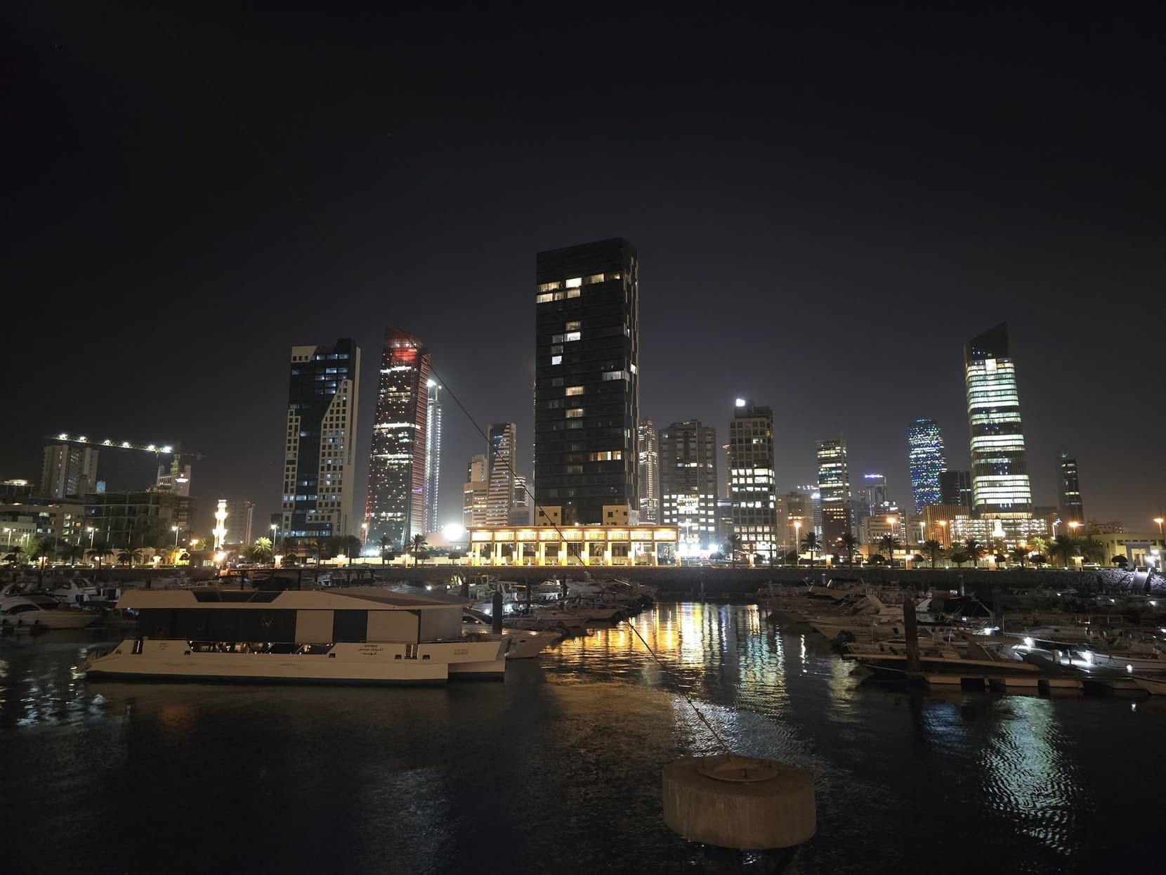 The night skyline from the marina, towers lit along the water