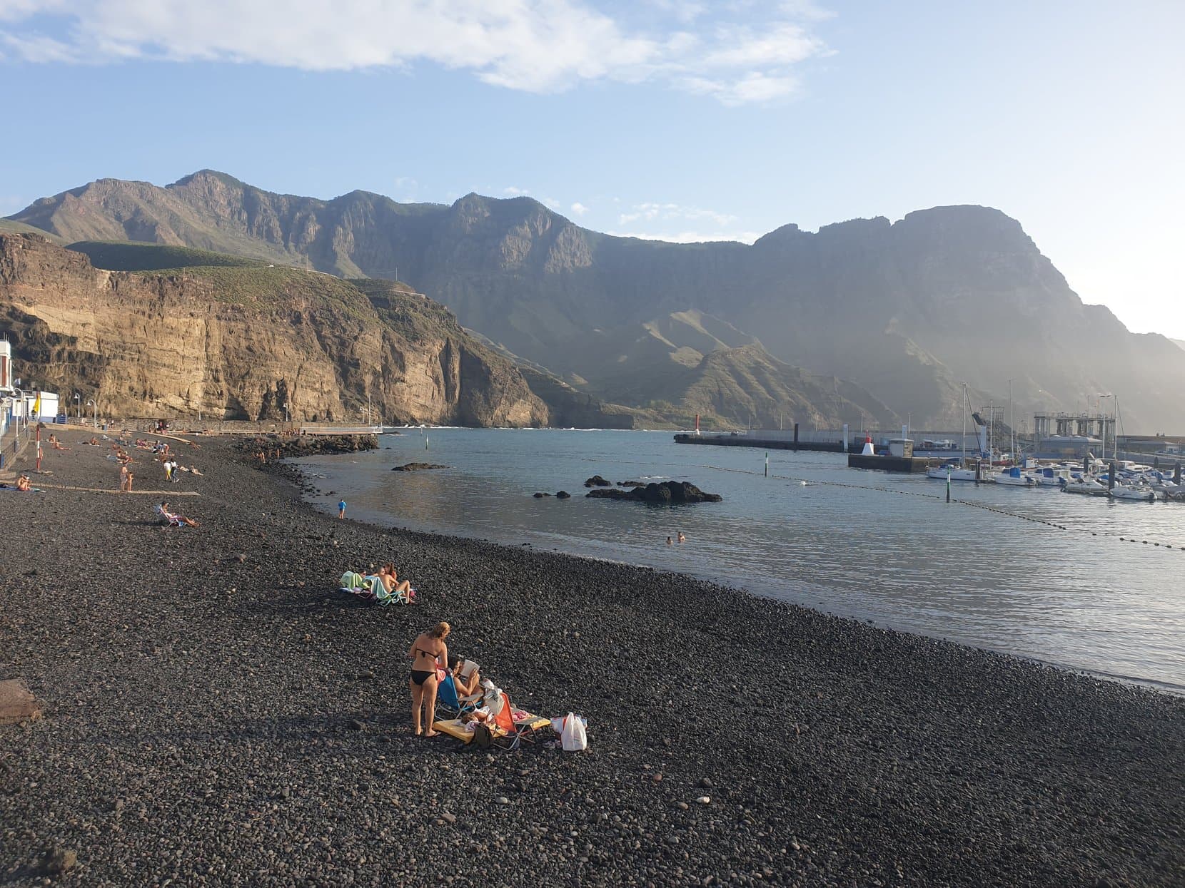 The dark pebble beach of Playa de las Nieves under high cliffs at Agaete, Gran Canaria