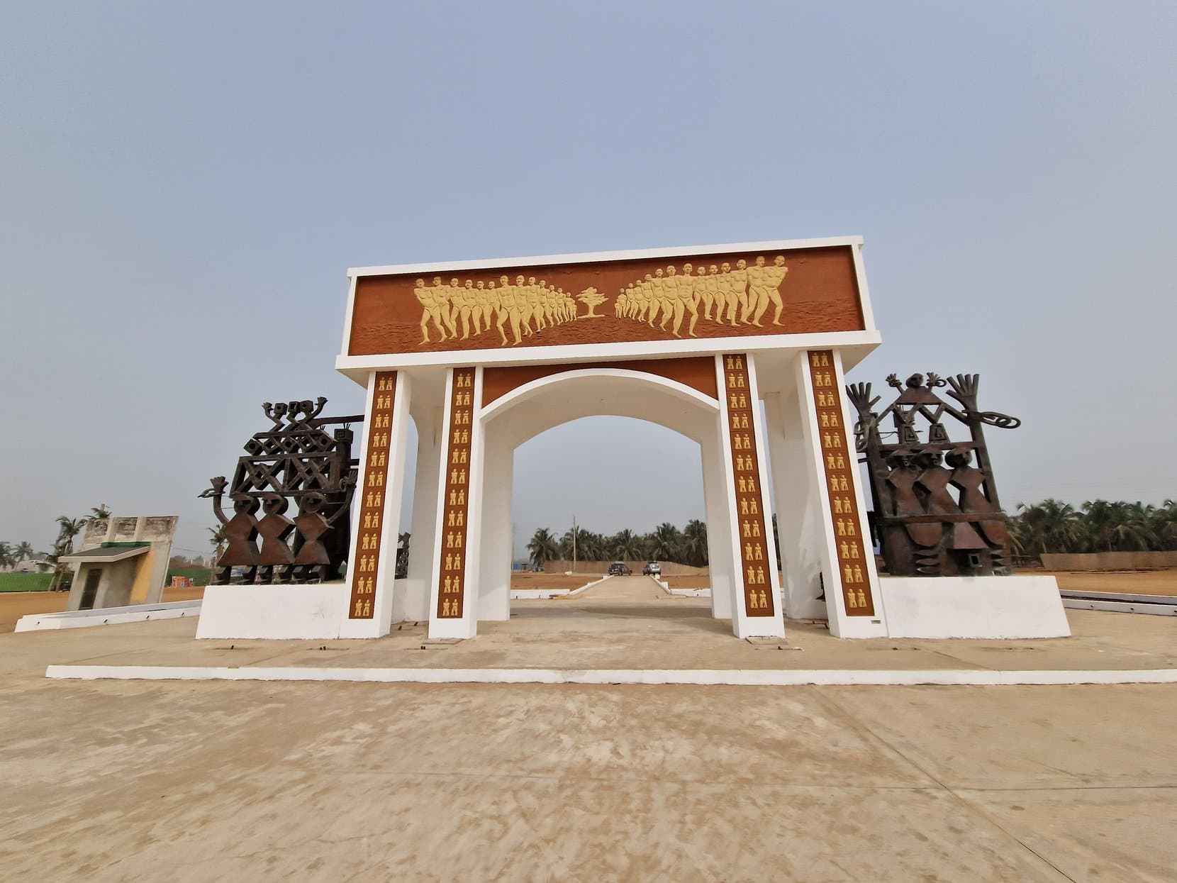 The Porte du Non-Retour memorial arch seen from the landward approach, with the haze of the sea through its opening, Ouidah, Benin