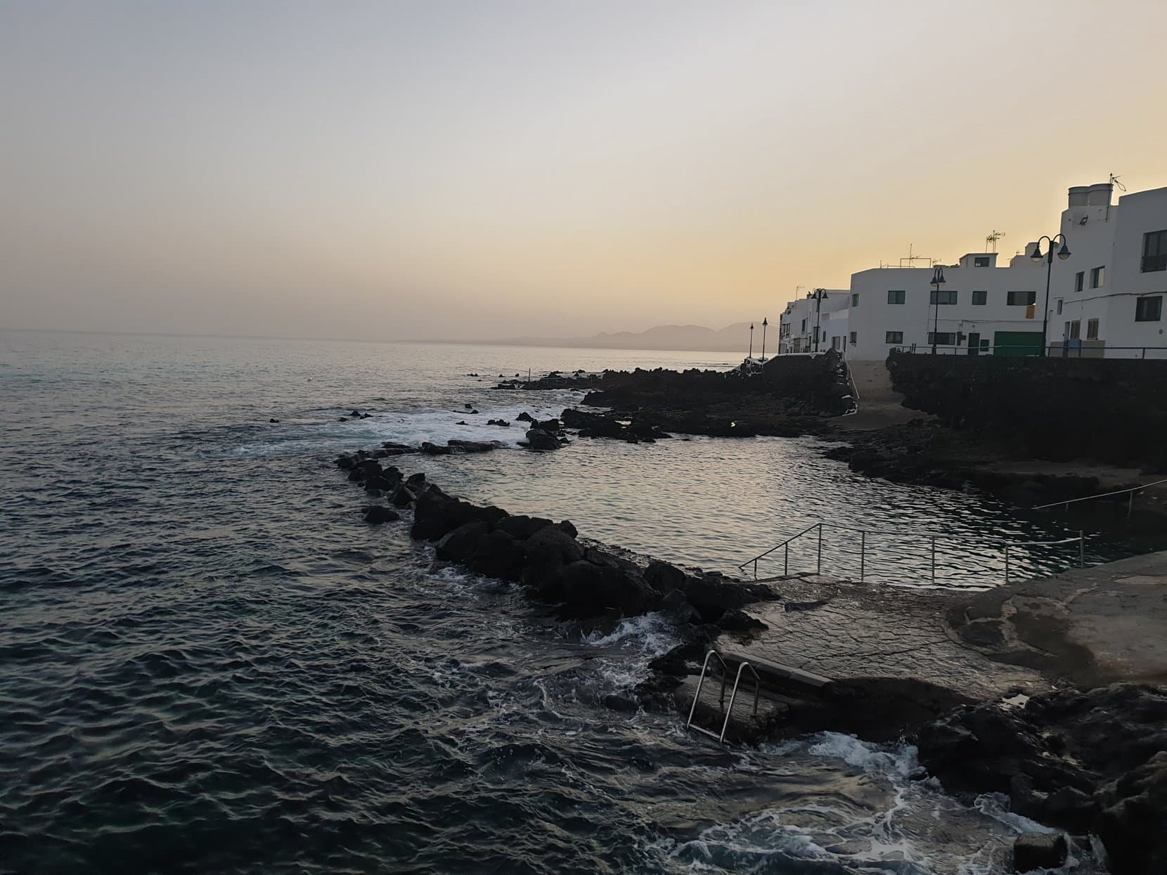 A natural seawater pool between lava rocks at Punta Mujeres at dusk, Lanzarote