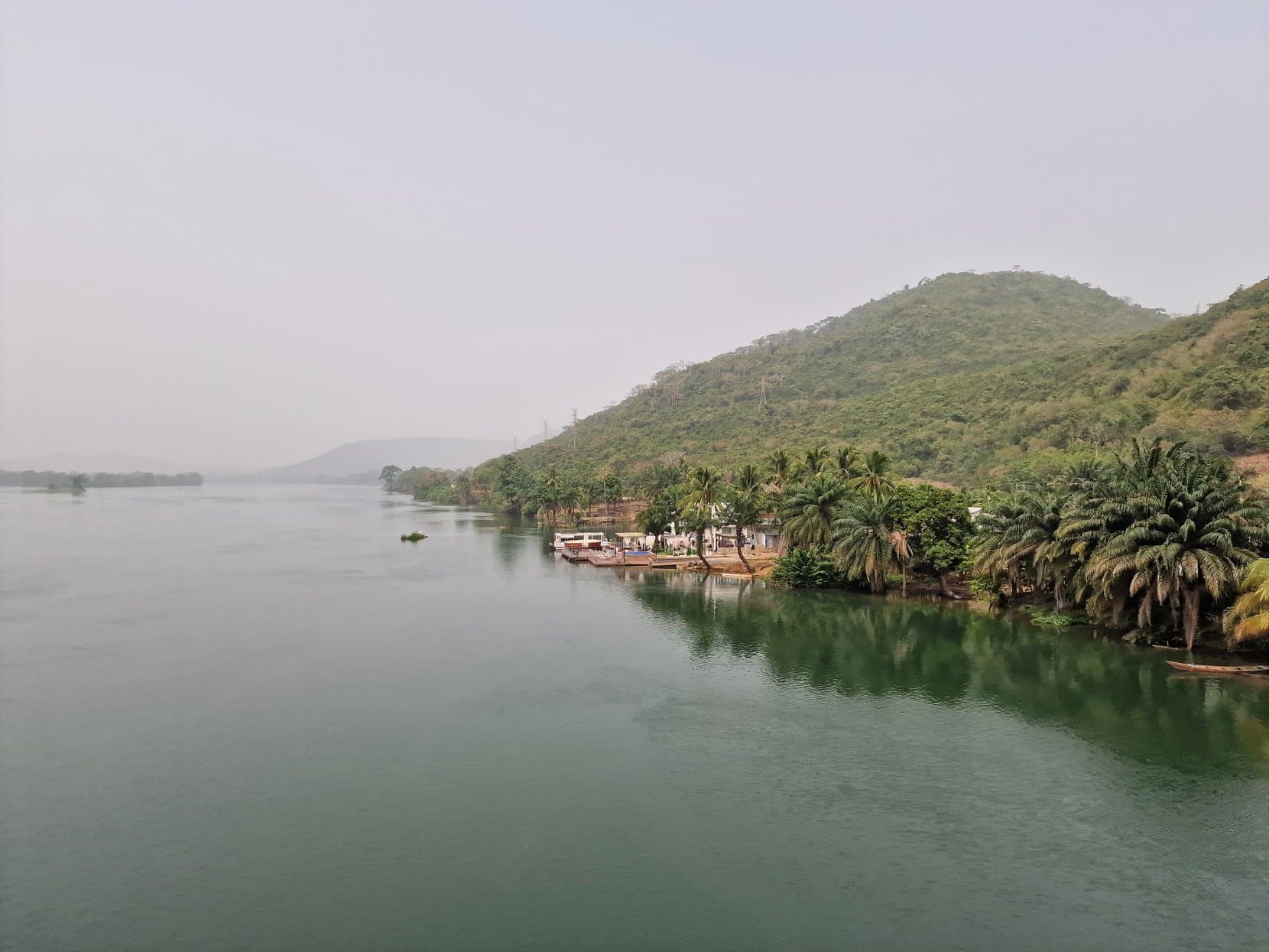 A wide river below green forested hills on the road east into Ghana's Volta region