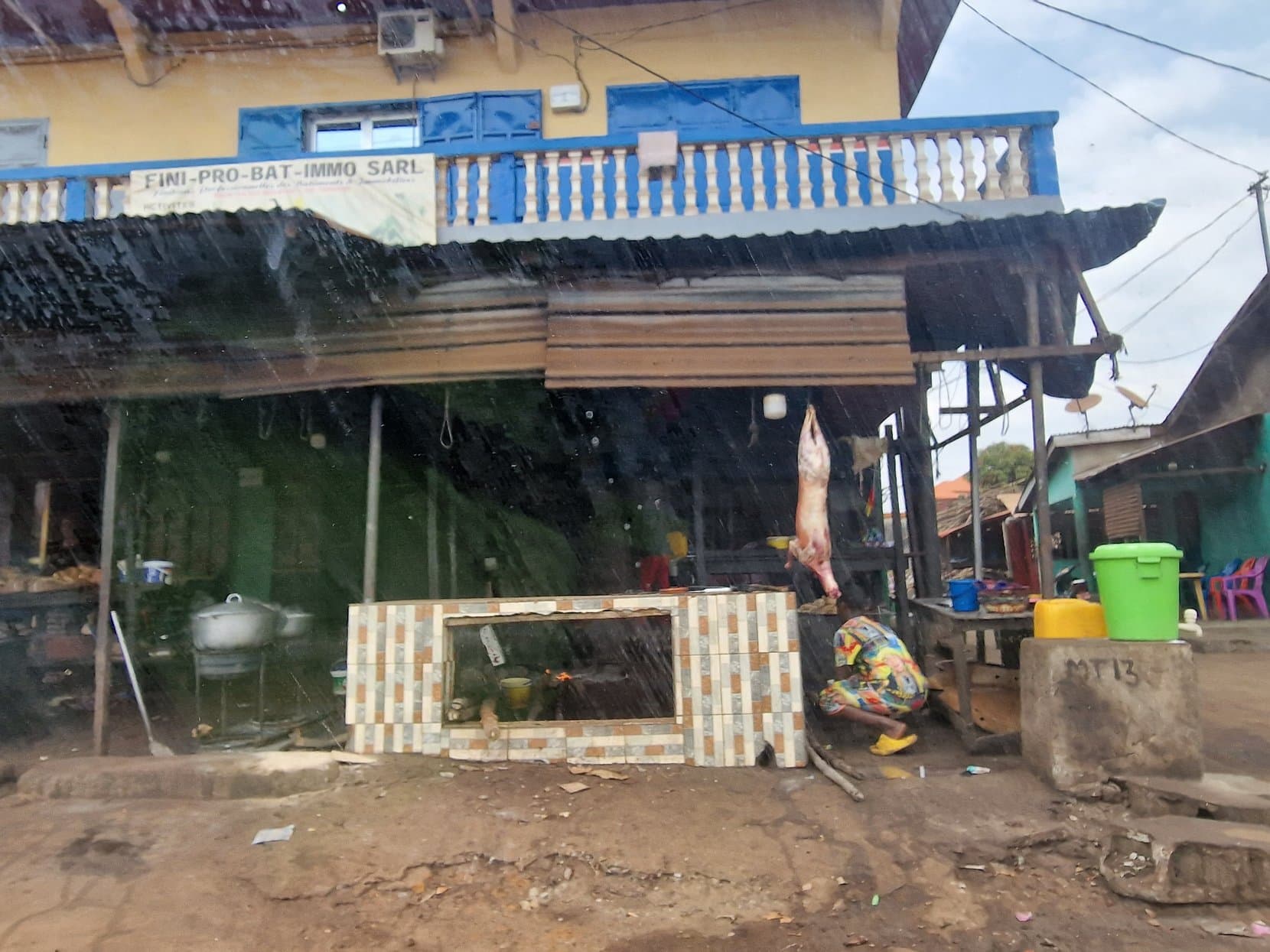 A roadside kitchen and butcher under an awning on the highway east of Conakry, Guinea