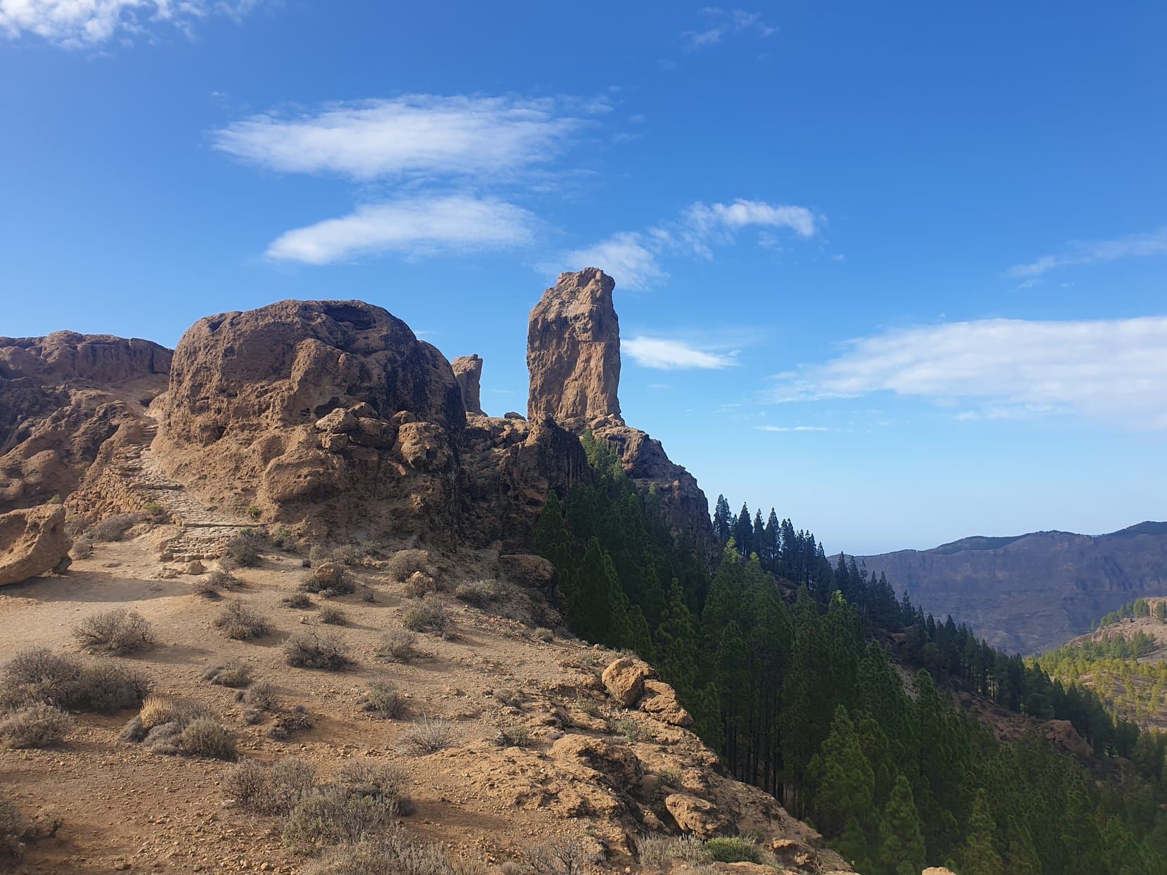 Roque Nublo and El Fraile standing over the plateau with pine forest dropping away behind, Gran Canaria