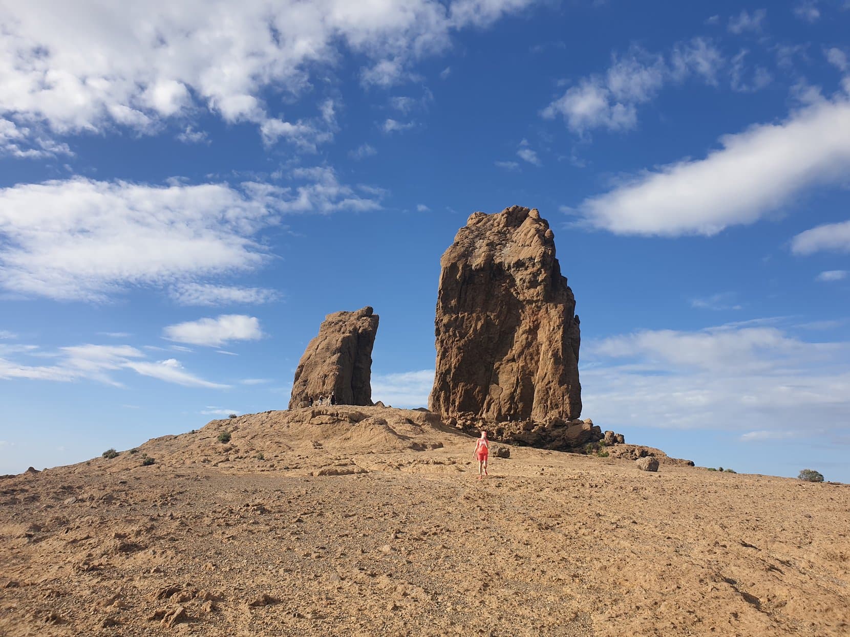 Roque Nublo and El Fraile up close, a walker tiny at the base, Gran Canaria