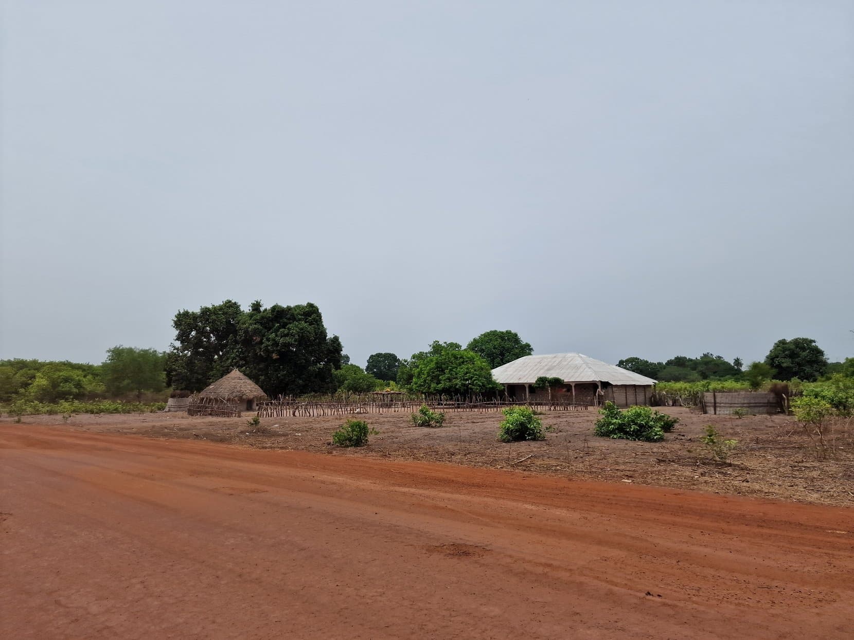 Round thatched huts standing across dry open ground