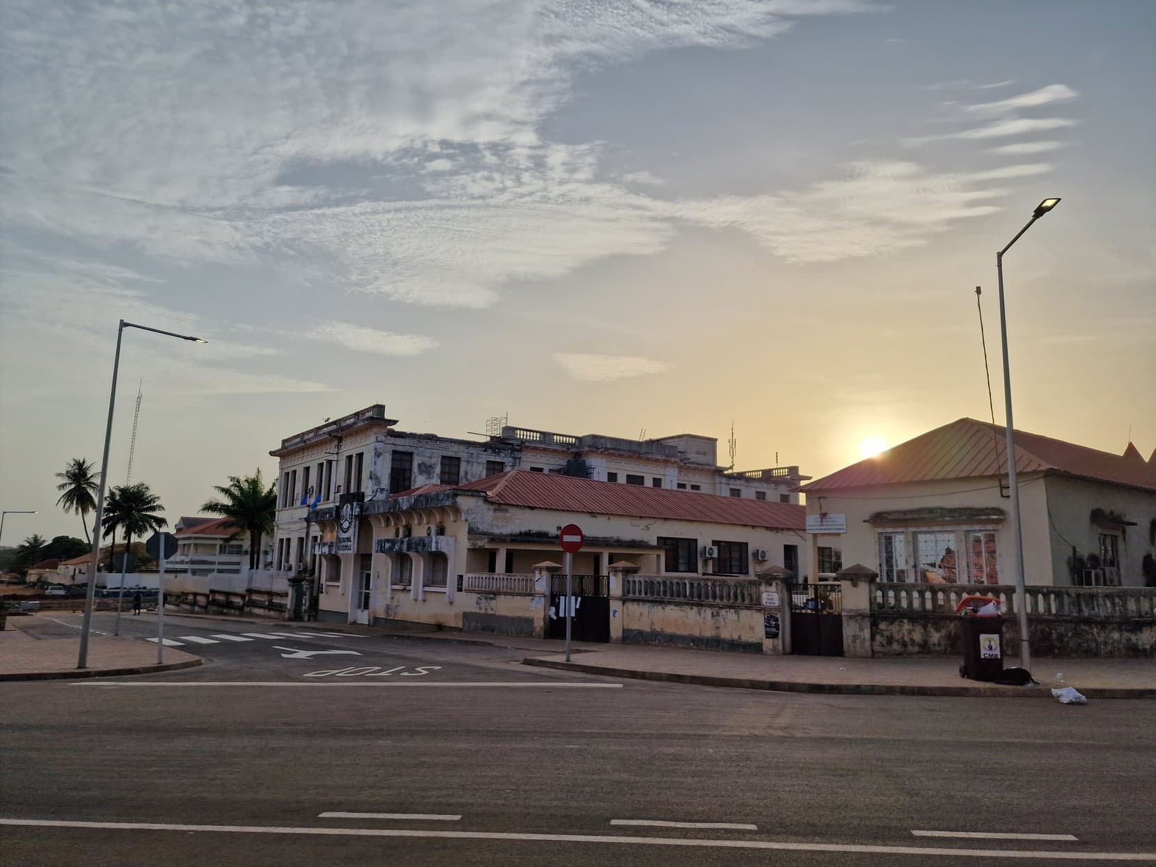 Sunset behind the colonial roofline at a junction in Bissau