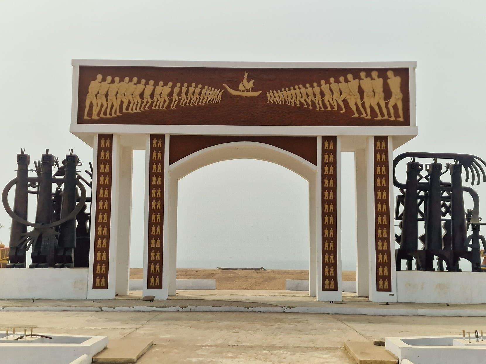 The Porte du Non-Retour memorial arch with its iron sculpture columns on the beach at Ouidah, Benin
