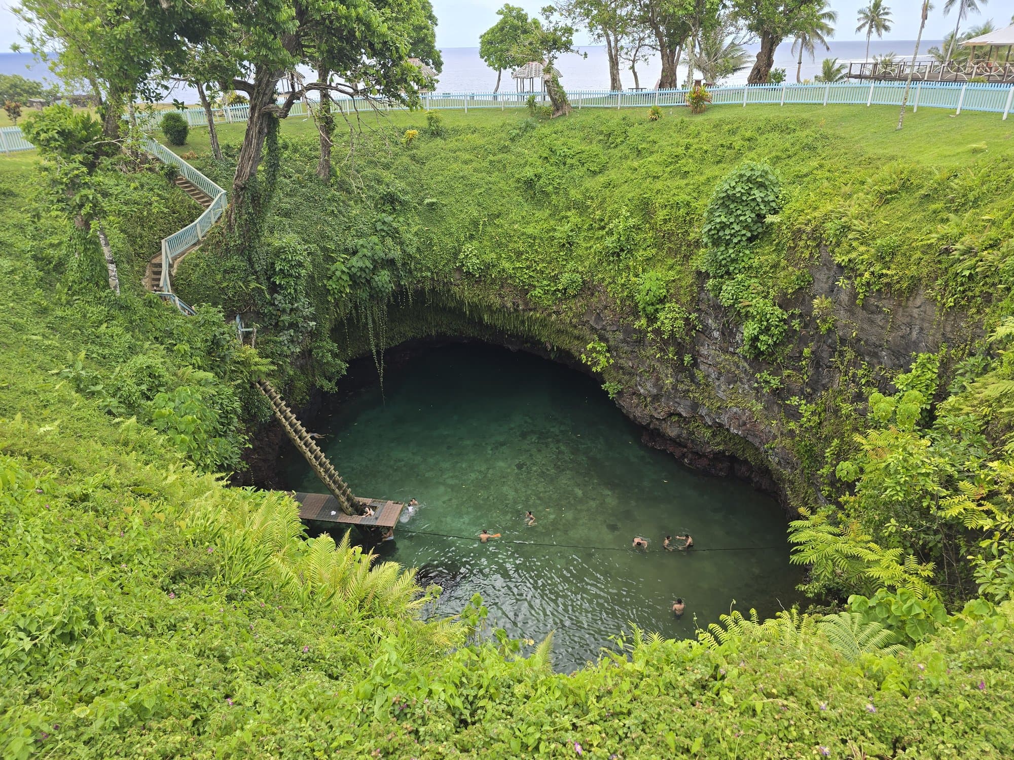 To-Sua Ocean Trench from the rim, the ladder down to swimmers in the green pool