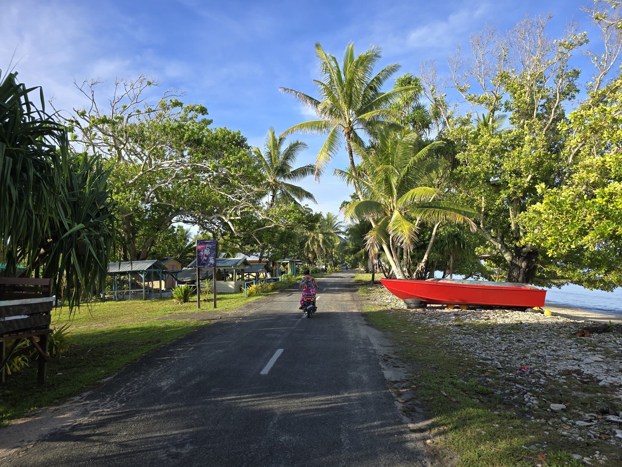 The village main road with a red skiff parked beside it