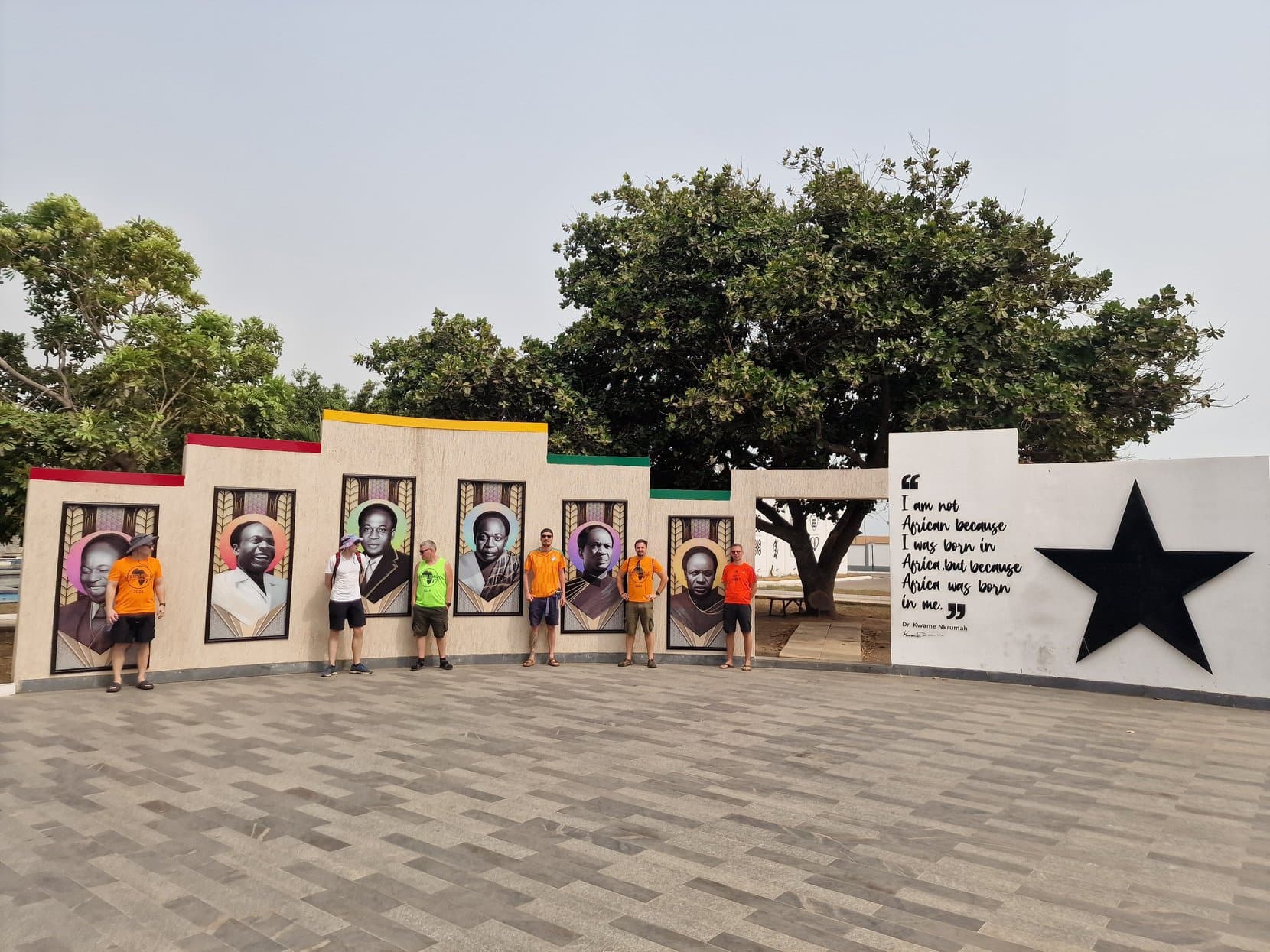 An outdoor wall of portraits of Ghana's past presidents beside a Black Star, Accra