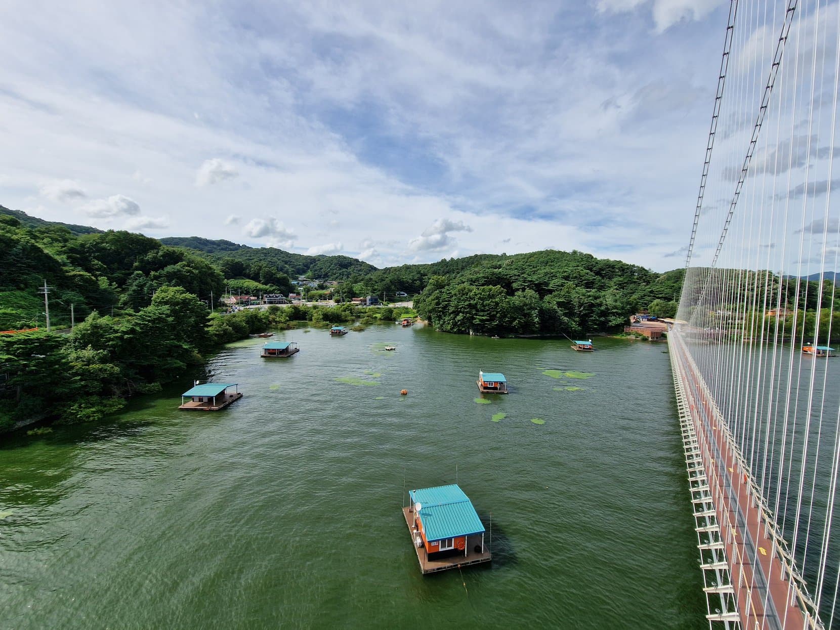 The Yedangho suspension bridge over a lake with floating houses, Yesan, South Korea