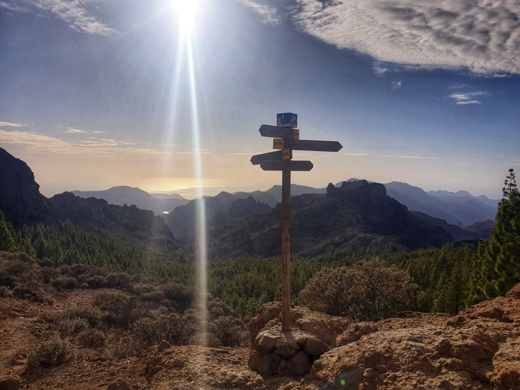 A trail signpost at a mirador over Gran Canaria's mountain heart at dusk